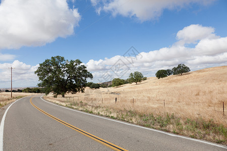 马丽珀萨脚下山山麓旅行农村农田丘陵天空树木金子草地风景背景图片