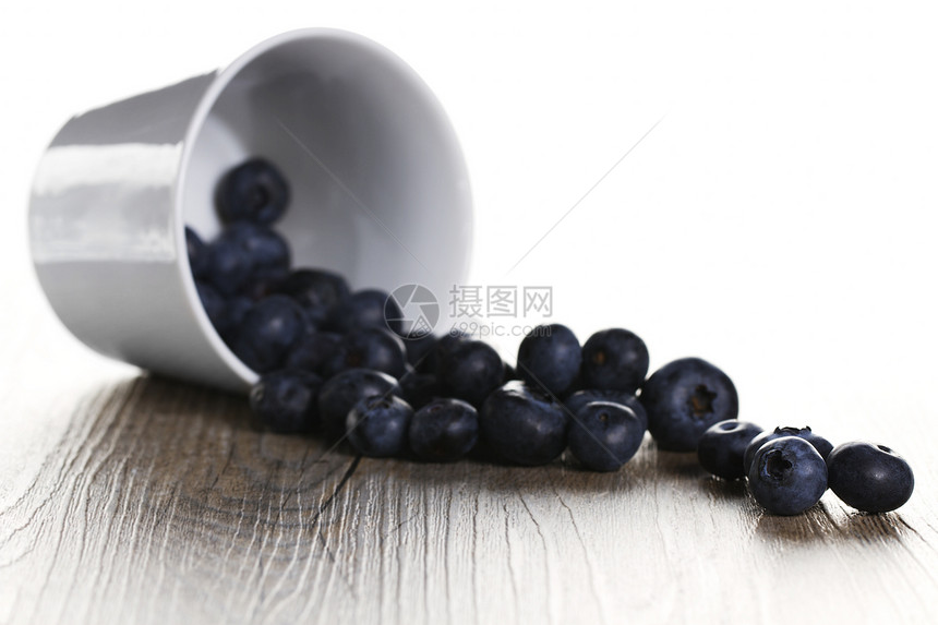 蓝莓从杯子上倒下滚动季节厨房背光食物饮食浆果白色水果小吃季节性图片