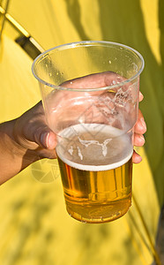 啤酒杯液体酒精阳光塑料黄色啤酒泡沫海滩背景图片