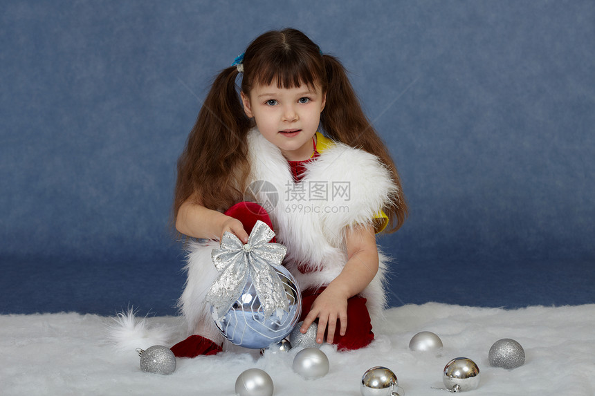 孩子坐在蓝色和圣诞树球一起坐蓝的图片