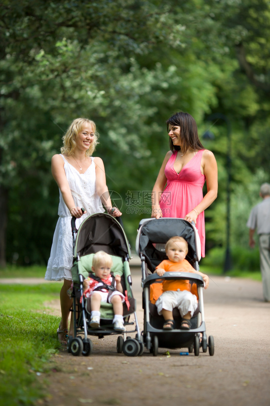 快乐的母亲婴儿车孩子喜悦家庭女性后代人行道衣服成年人公园图片