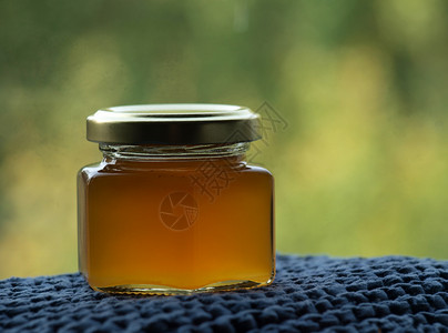 波罗海蜜蜂蜂蜜罐波纹木头六边形蜜蜂早餐厨房金子桌子液体森林背景