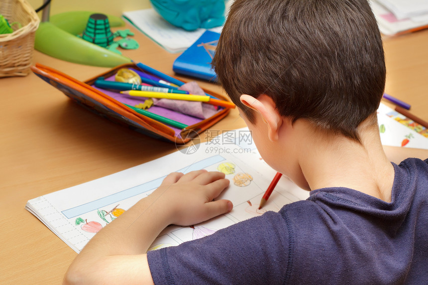男孩用彩色铅笔 绘画水果做家庭作业沉思教育兄弟姐妹创造力水平学校地理青少年桌子字典图片
