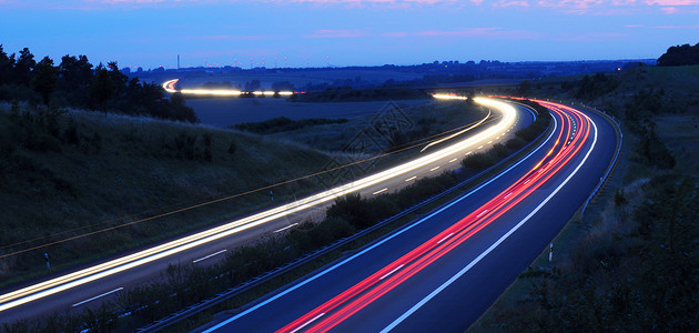 高速公路上夜间交通大灯车道汽车天空小时运输街道小径红色头灯背景图片