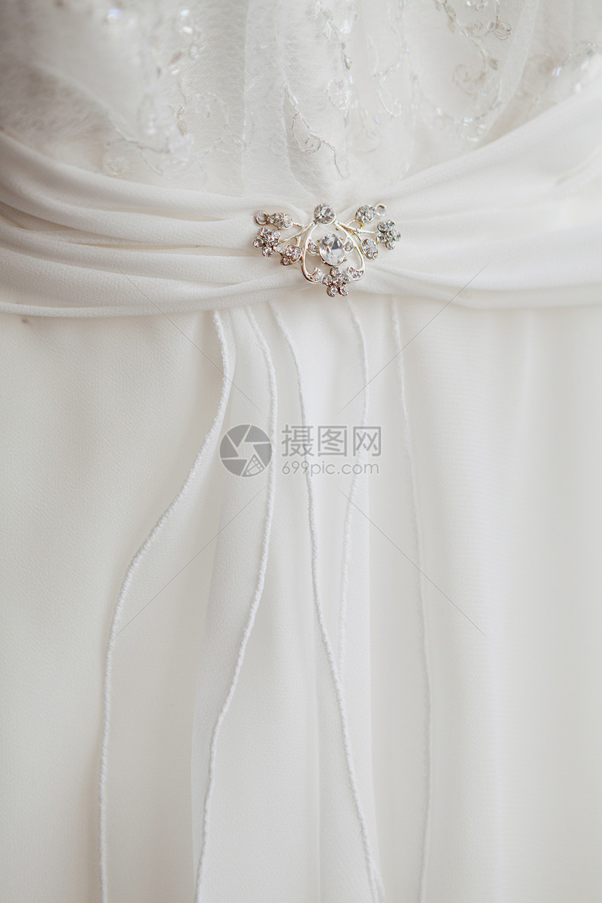 一件有胸针的礼服的一部分婚礼刺绣蕾丝按钮衣服别针宏观薄纱拉刀白色图片
