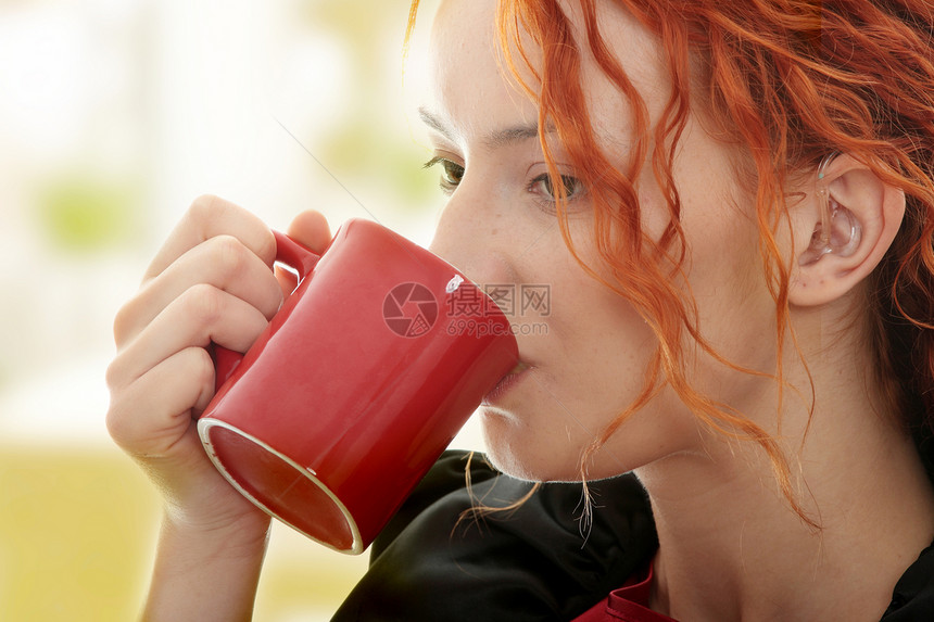 美丽的聋哑女子享受饮料人士女士助听器闲暇拿铁学生咖啡图片