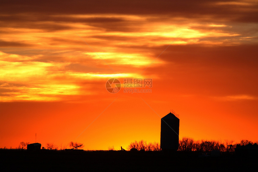 由多彩的日落所环绕的筒仓天空水平橙子乡村色彩黄色红色农村美术地平线图片