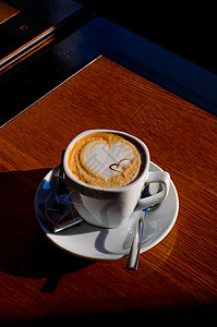 卡布奇诺时间拿铁叶子桌子泡沫巧克力咖啡师杯子咖啡馆牛奶早餐背景图片