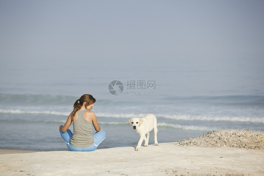 女孩带着她的狗自由小狗猎犬宠物闲暇海滩海岸动物海洋假期图片