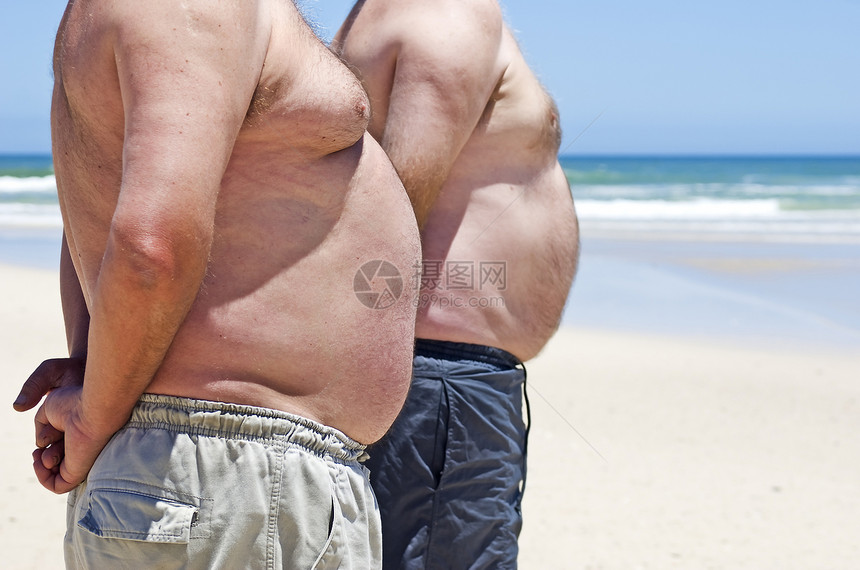 海滩上两个胖胖胖子相亲近橘皮圆形男人腰围疾病重量饮食身体成人男性图片