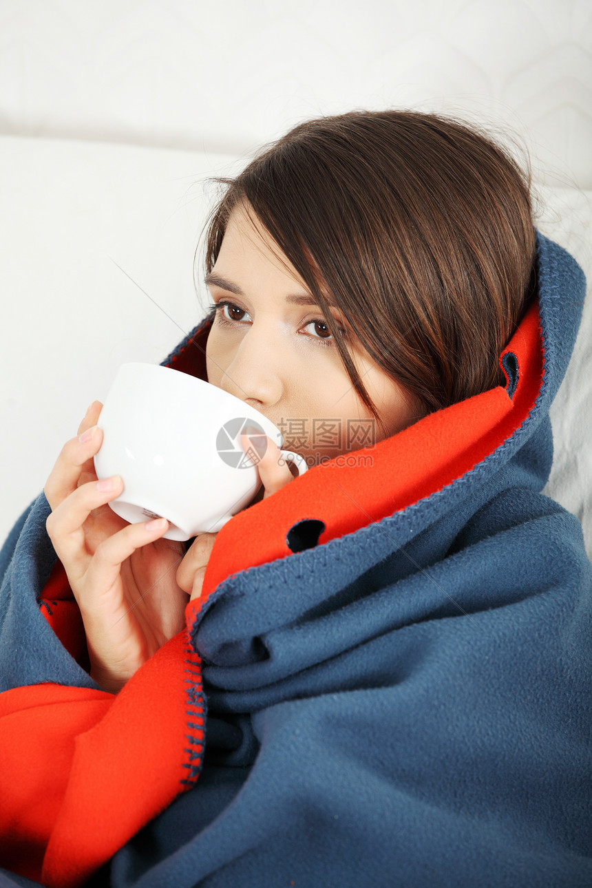 年轻女人感冒了卫生冷冻季节发烧毯子毛衣保健杯子黑发温度图片