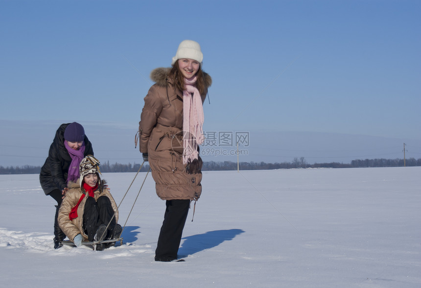 三个快乐的姐妹在冬天滑雪女性乐趣帽子享受友谊雪橇速度兄弟手套姐姐图片