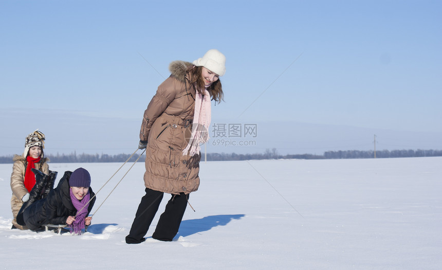 三个快乐的姐妹在冬天滑雪行动雪橇女性衣服青少年速度姐姐幸福童年享受图片