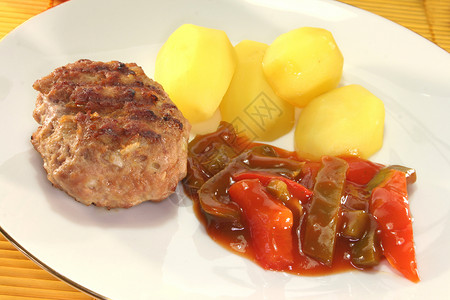 与拉塔图伊的肉球肉丸猪肉红色胡椒土豆牛肉绿色法庭午餐背景图片