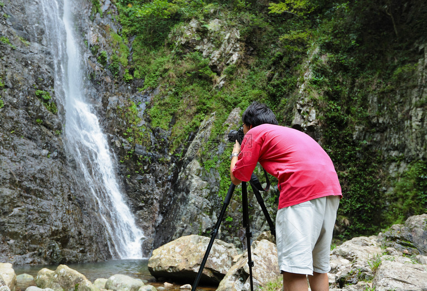 拍摄瀑布照片的摄影记者体积男人旅游远足力量男性吸引力激流摄影师荒野图片
