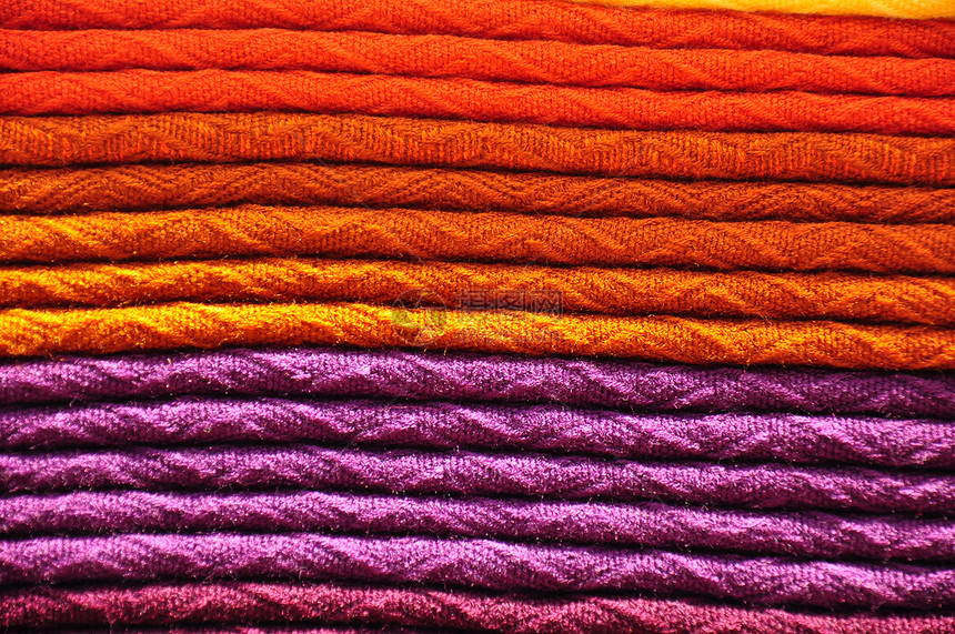 以橙色和紫色形式堆放着传统的黄羊毛毯图片