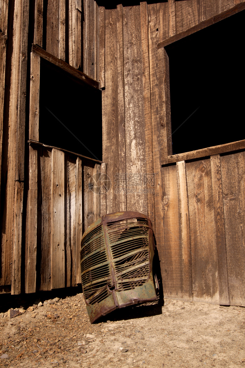 一个生锈的老卡车烧烤炉对一个谷仓运输褪色汽车金属破坏车轮乡村古董腐蚀风化图片