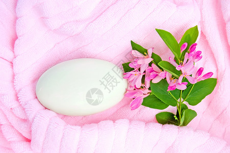 粉红色毛巾上的肥皂背景图片