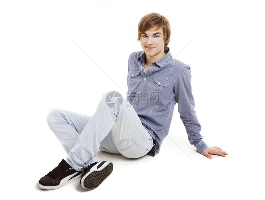 坐在地板上的年轻男人男性蓝色思维成人冒充地面工作室微笑快乐金发图片