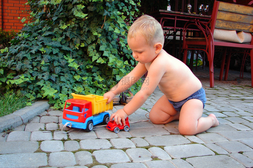 那孩子在院子里有玩具花园生活儿童白色乐趣绿色男生蓝色晴天轮子图片