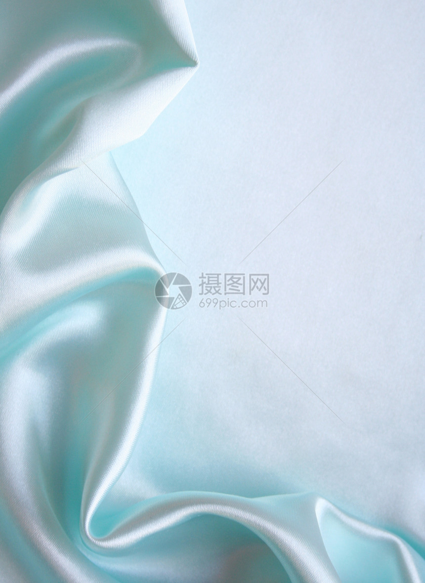 平滑优雅的蓝色丝绸作为背景折痕材料版税感性曲线织物银色海浪纺织品生产图片