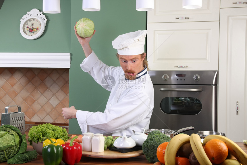 在厨房准备午餐的年轻厨师帽子工人烤箱乐趣蔬菜男人食物服务衣服盘子图片