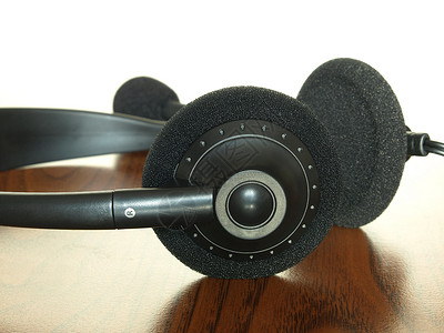 木桌上的黑耳机宏观麦克风电话黑色立体声桌子背景图片