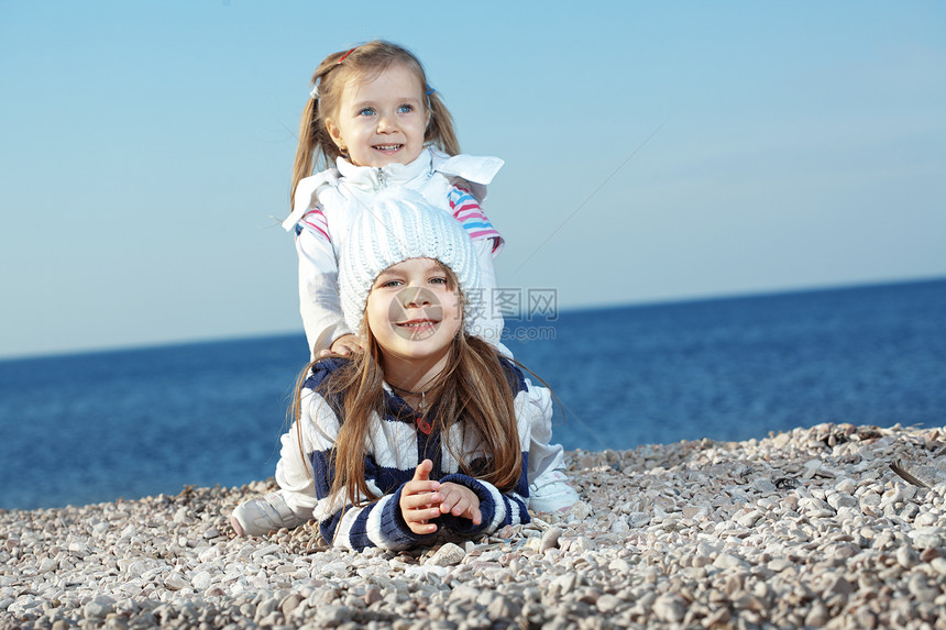 海滩上的孩子闲暇拥抱童年孩子们衣服快乐儿童游戏友谊女孩们图片