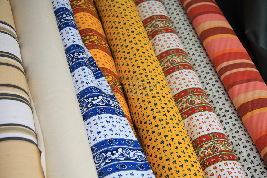 在一个市场摊位上的证明人纺织品卷展示销售零售桌布棉布织物纺织品图片