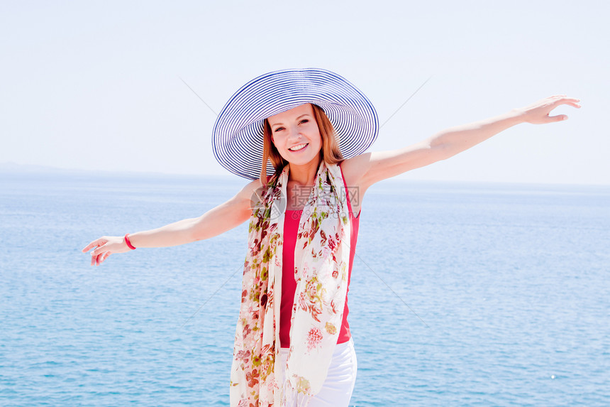 女孩在岩石上海对岸头发沉思女性海岸线海滩幸福青年河岸边缘地平线图片