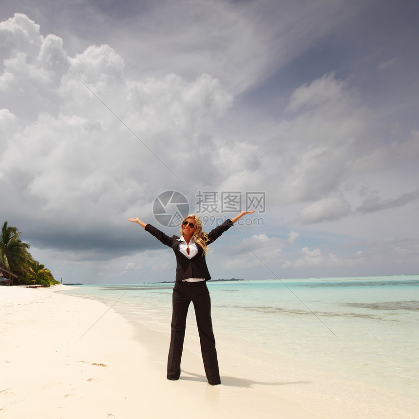 海洋海岸上快乐的女商务人士旅行金发女郎假期海滩晴天天空成人套装人士工人图片