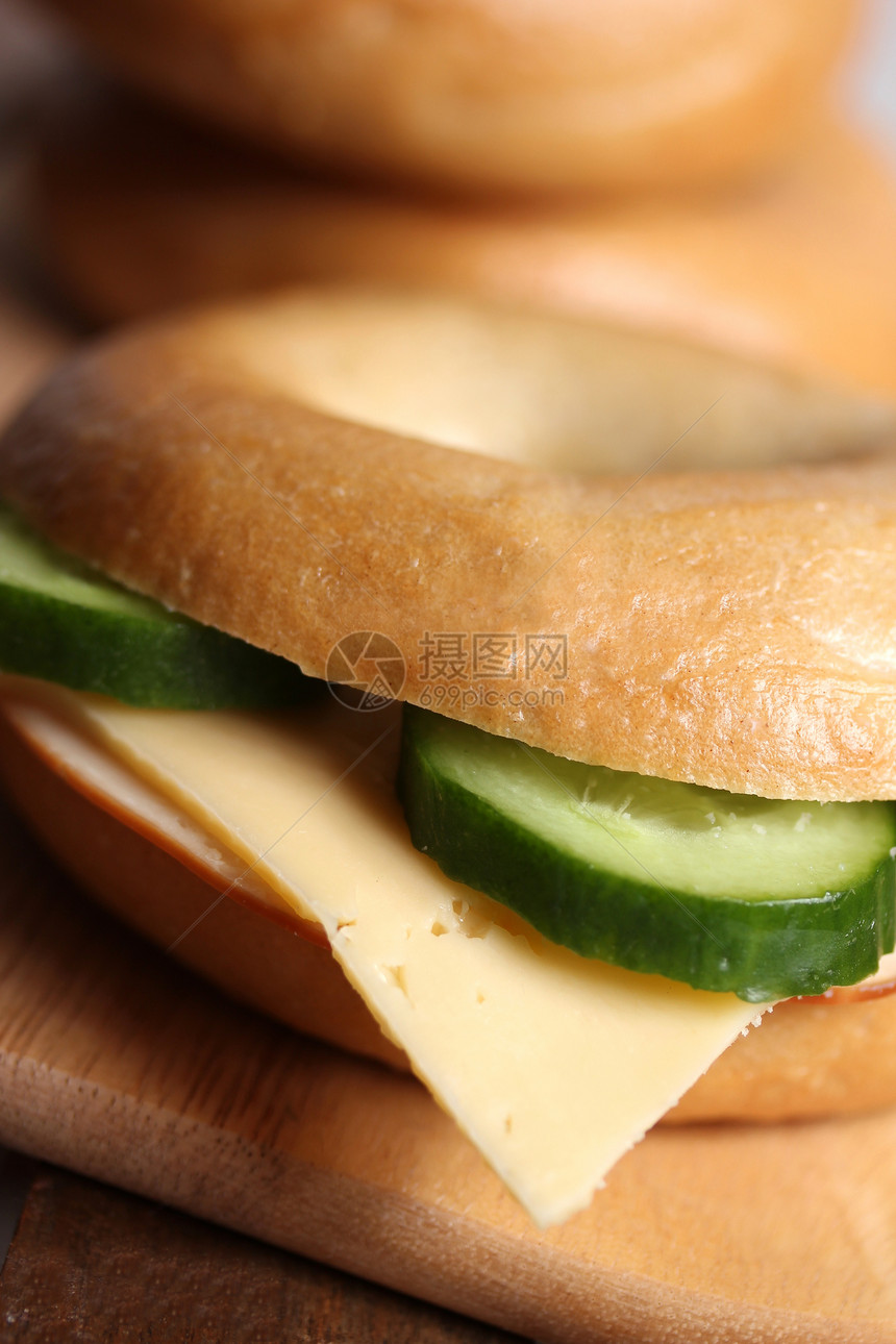 新鲜奶酪和火腿面包圈包子黄瓜奶油圆形牛奶午餐美食木头熟食面包图片