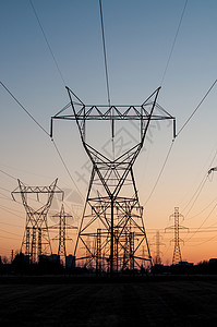 日落时电输电塔电平极电网传输棕色线路高压照片天空力量电力电能背景图片