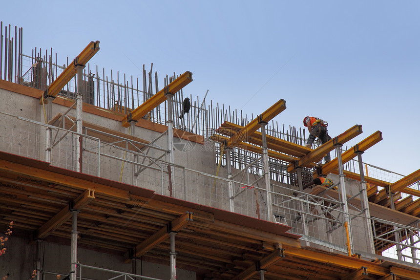 工人在建造钢梁办公室BUI期间参与行动建筑职业男人头盔危险建设者劳动安全摩天大楼工业图片