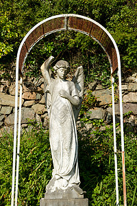 天使雕像雕刻金属框架植物翅膀底座石头宗教背景图片