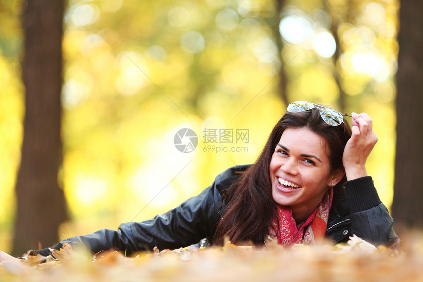 秋叶中的妇女脚尖叶子女士女性头发季节乐趣团体微笑眼睛女孩图片