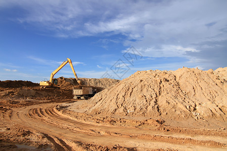 CO2在室外工作时进行挖土作业的挖掘机装载机蓝色天空土壤反铲机械建筑机器车辆挖掘刀刃活动高清图片素材