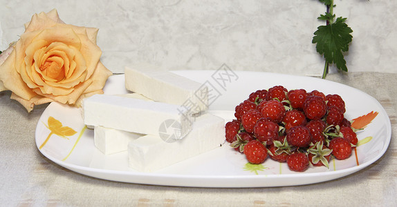 甜甜的白水果糖果和盘子上的草莓玫瑰陶瓷浆果覆盆子灰色红色白色制品背景图片
