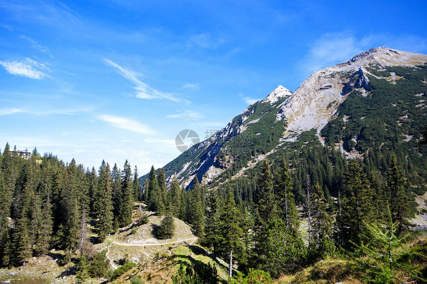 巴伐利亚山的阿尔卑斯山石头荒野天空树木旅行蓝色森林远足农村风景图片