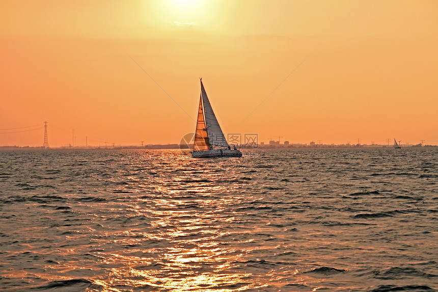 日落时在荷兰IJsselmeer号上航行游艇运动娱乐风帆帆船图片