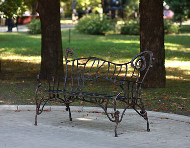 夏季公园的金属制成板凳漩涡寂寞灰色边界银行悲伤叶子长椅木头锤击背景