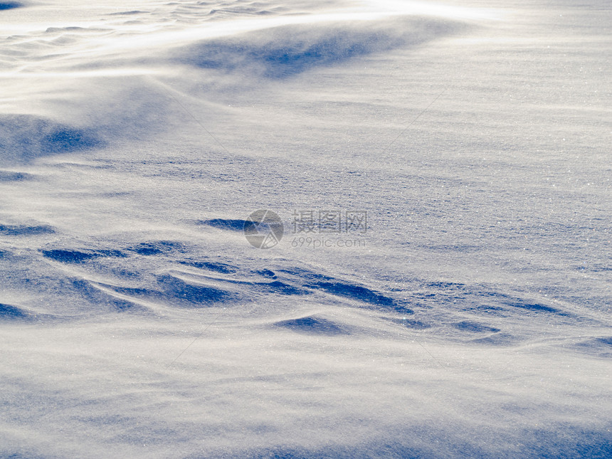 风飘雪 在雪地表面重飞水晶阳光蓝色阴影天气雪堆漂流降雪礁石气候图片