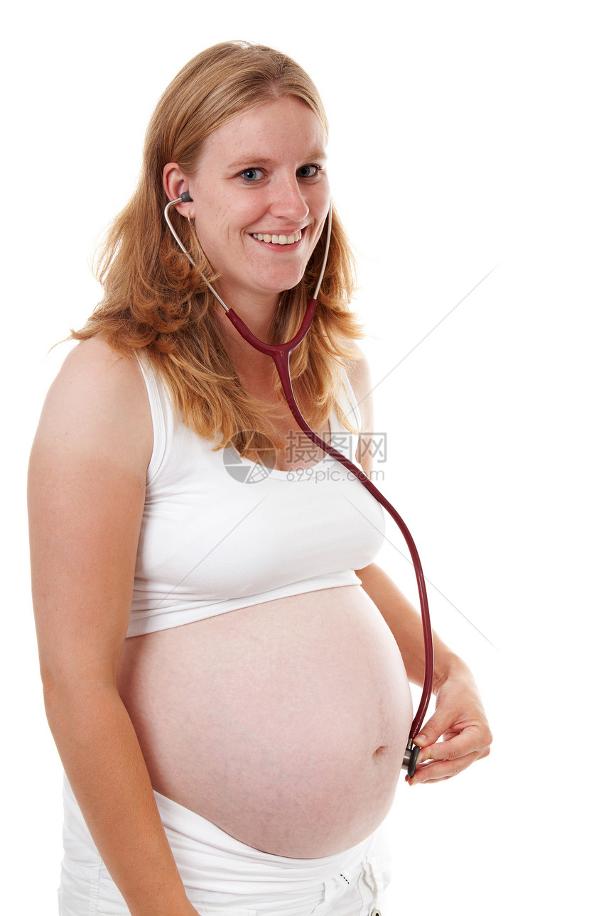母亲在孕妇肚子上用听诊器监听图片