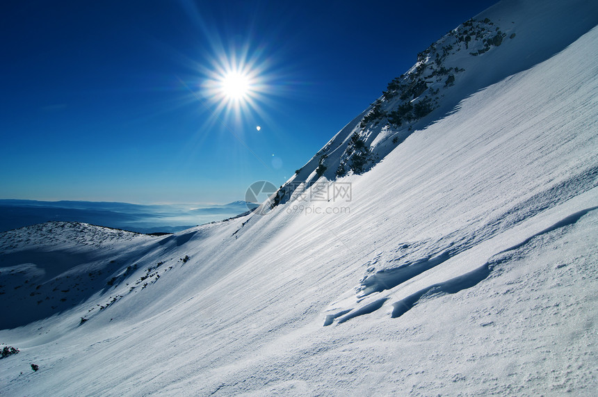 冬季山地景观旅行旅游暴风雪阳光天空场景运动蓝色全景风景图片