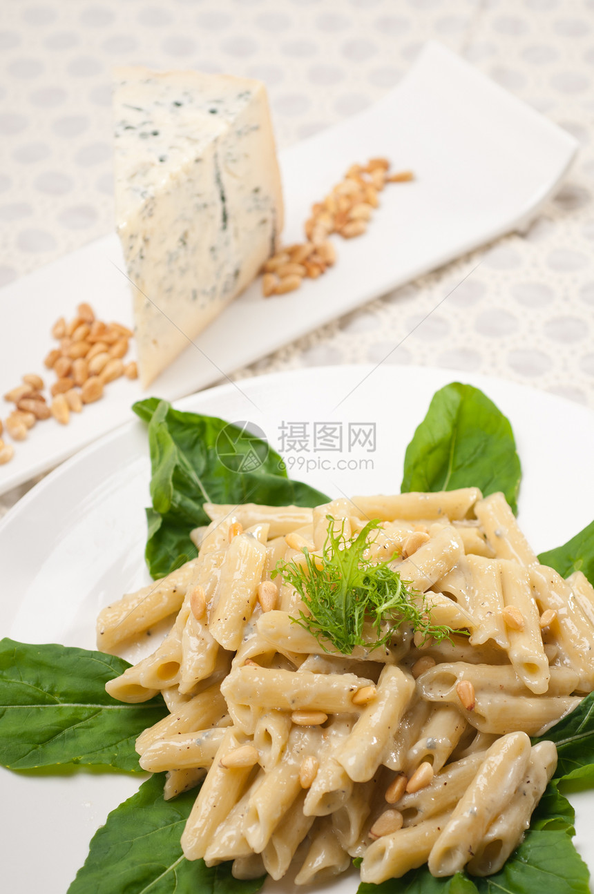 意大利通心粉戈贡佐拉和松子羊乳产品食物松树美食桌子草药盘子硬粒蓝色图片