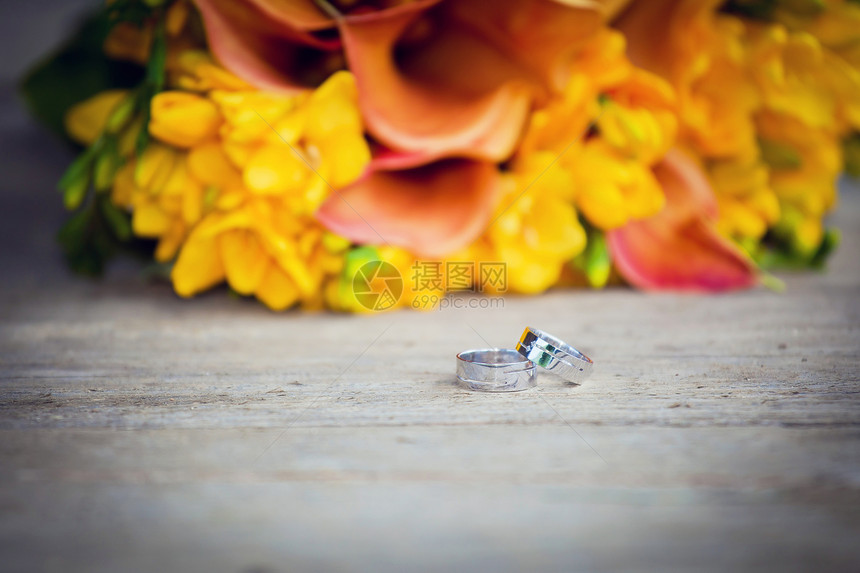 结婚戒指和婚礼花束婚姻玫瑰钻石珠宝庆典金属首饰仪式联盟礼物图片