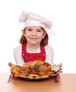 美丽的小女孩烹饪餐桌上的烤鸡和烤鸡孩子高清图片素材