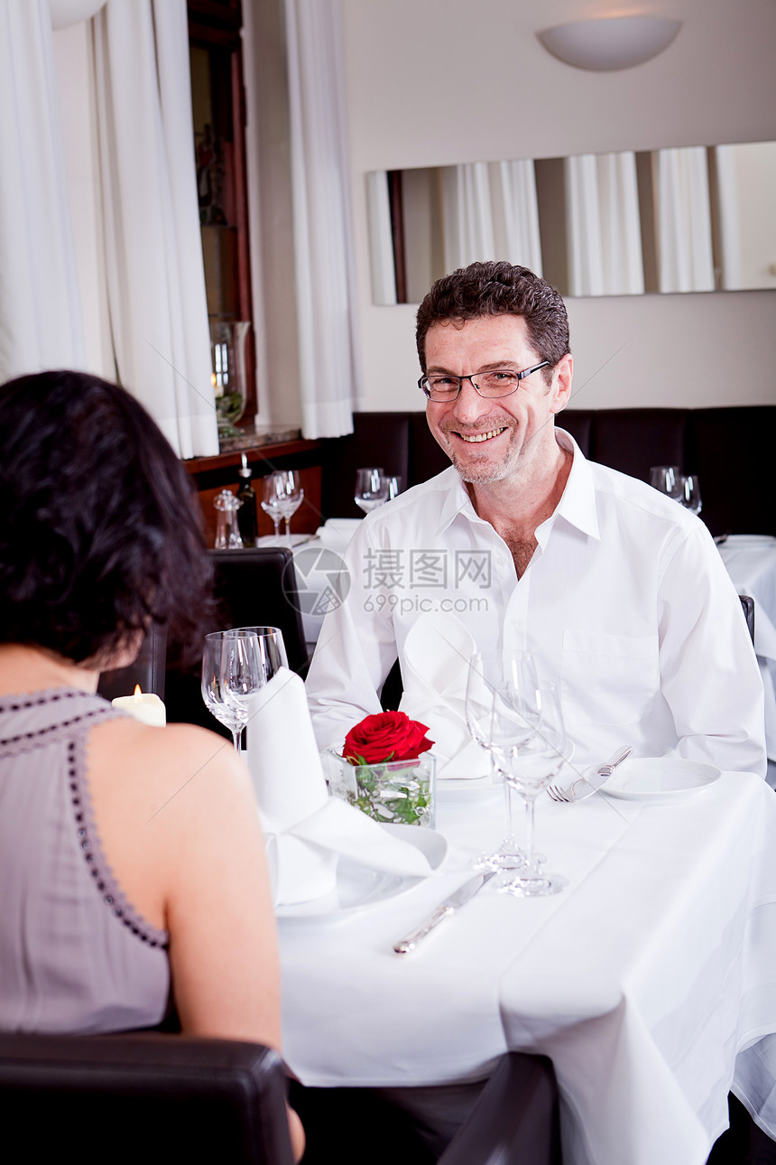 快乐的一对在餐厅笑着微笑的情侣女士用餐生日眼镜浪漫成人恋人酒精幸福周年图片