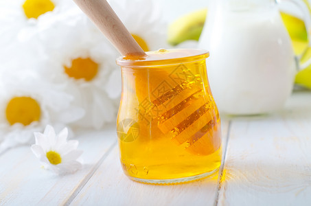 在玻璃库里的新鲜蜂蜜 和在罐中的牛奶早餐玻璃镜子金子木头营养产品液体生产食物背景图片
