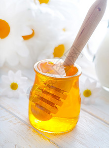 在玻璃库里的新鲜蜂蜜 和在罐中的牛奶镜子治愈食物生产金子木头玻璃营养液体早餐背景图片